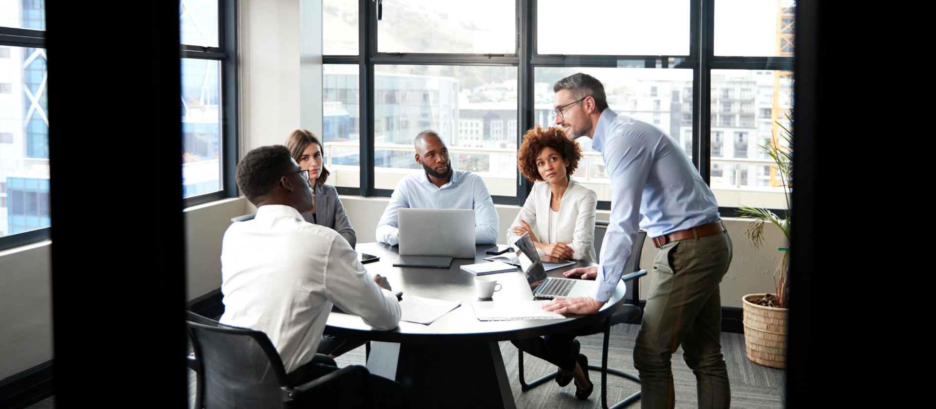 Eine gemischte Gruppe erfahrener Cloud-Mitarbeitenden besprechen sich in einem Meetingraum