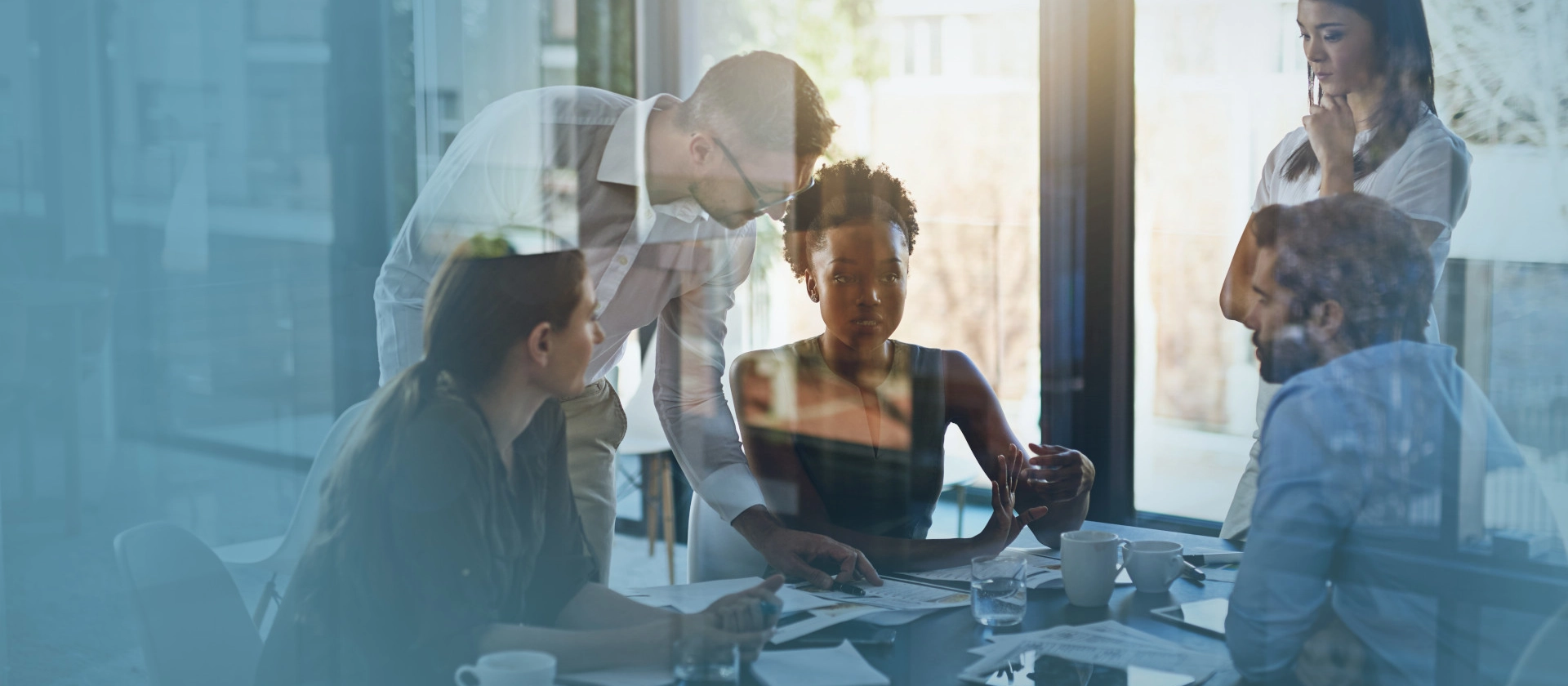 Eine gemischte Gruppe von Managern der Branche Utilities bespricht sich in einem Meetingraum