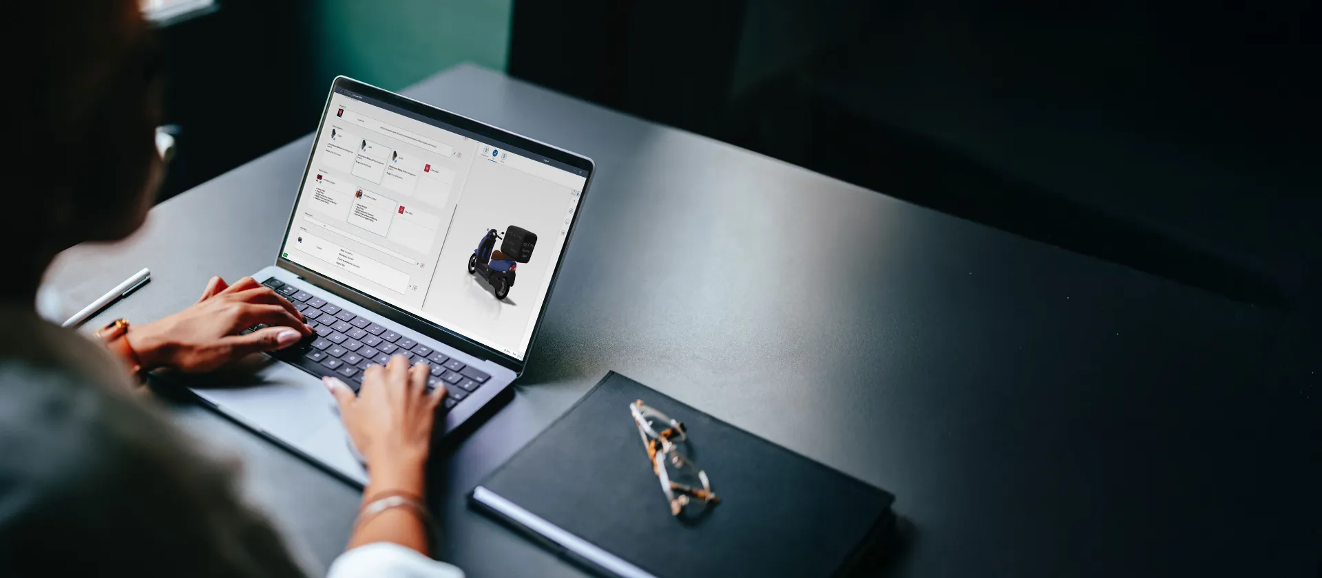Person arbeitet an einem Laptop und erstellt ein 3D-Modell eines Elektrorollers.
