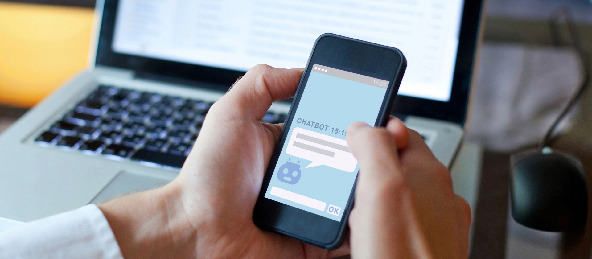 Chatbot auf Smartphone und Laptop im Hintergrund