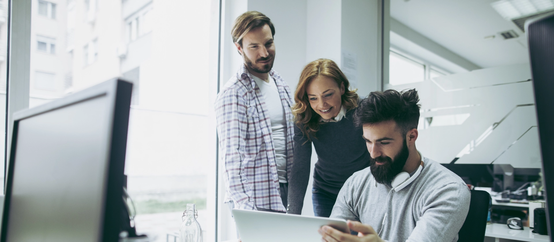 Drei Kollegen aus der Geschäftseinheit Consumer Products betrachten etwas auf einem Laptop