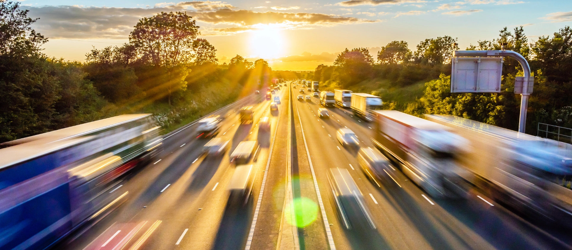 Schwerer Verkehr mit hoher Geschwindigkeit auf einer britischen Autobahn in England bei Sonnenuntergang