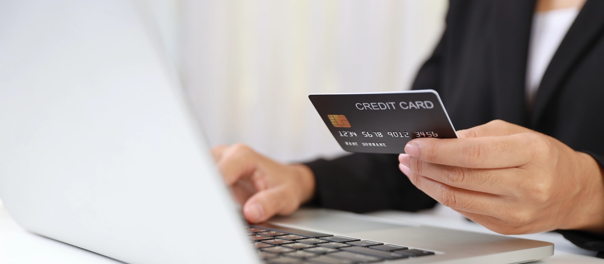 Frau mit Kreditkarte am Laptop