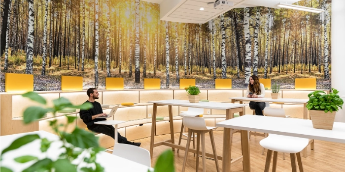 msg-Mitarbeitende auf den Sitzbänken in der Cafeteria am msg-Standort Frankfurt