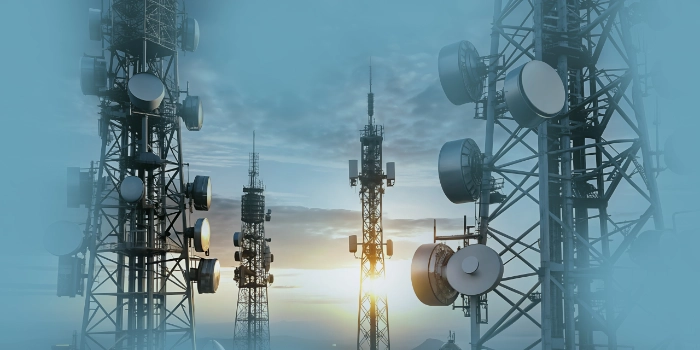 Mehrere Mobilfunkmasten, überlagert von blauer Vordergrundfarbe, Hintergrundbild für die Branche Telecommunications