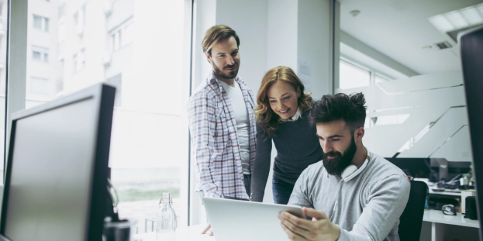 Drei Kollegen aus der Geschäftseinheit Consumer Products betrachten etwas auf einem Laptop