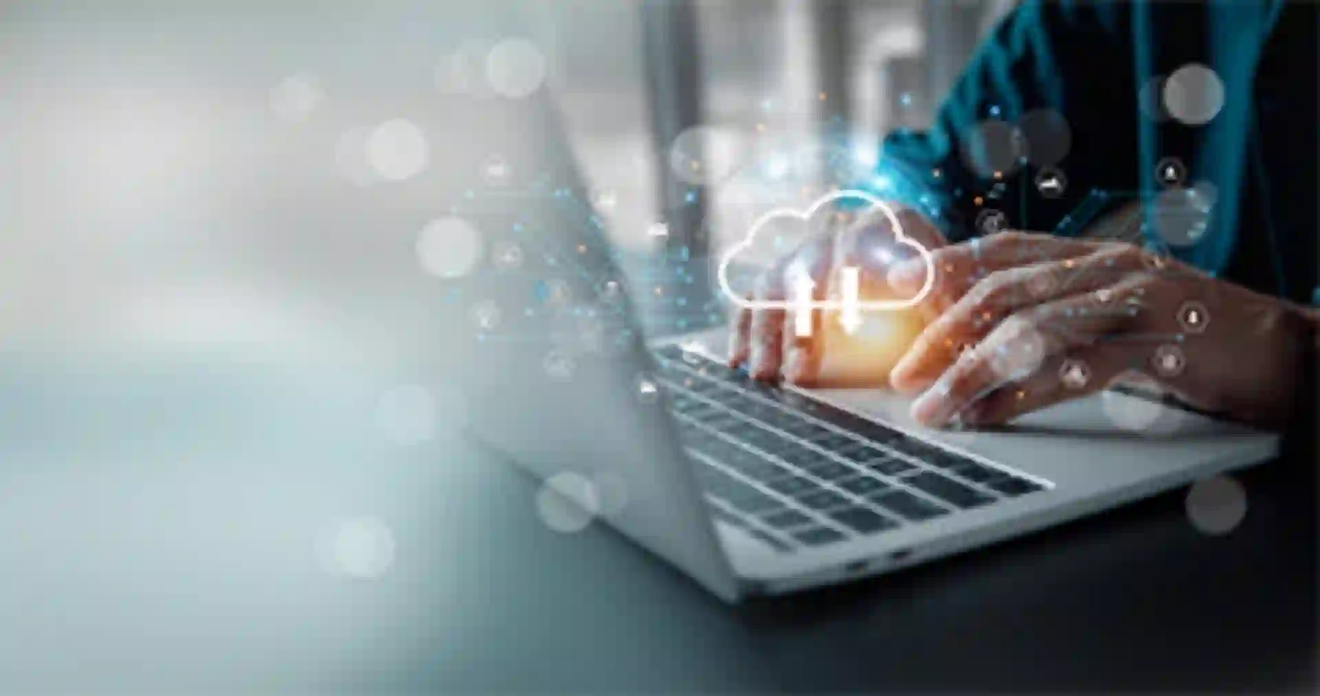 Hände tippen auf Laptop mit Cloud-Analytics-Symbol – steht für Datenanalyse in der Cloud.