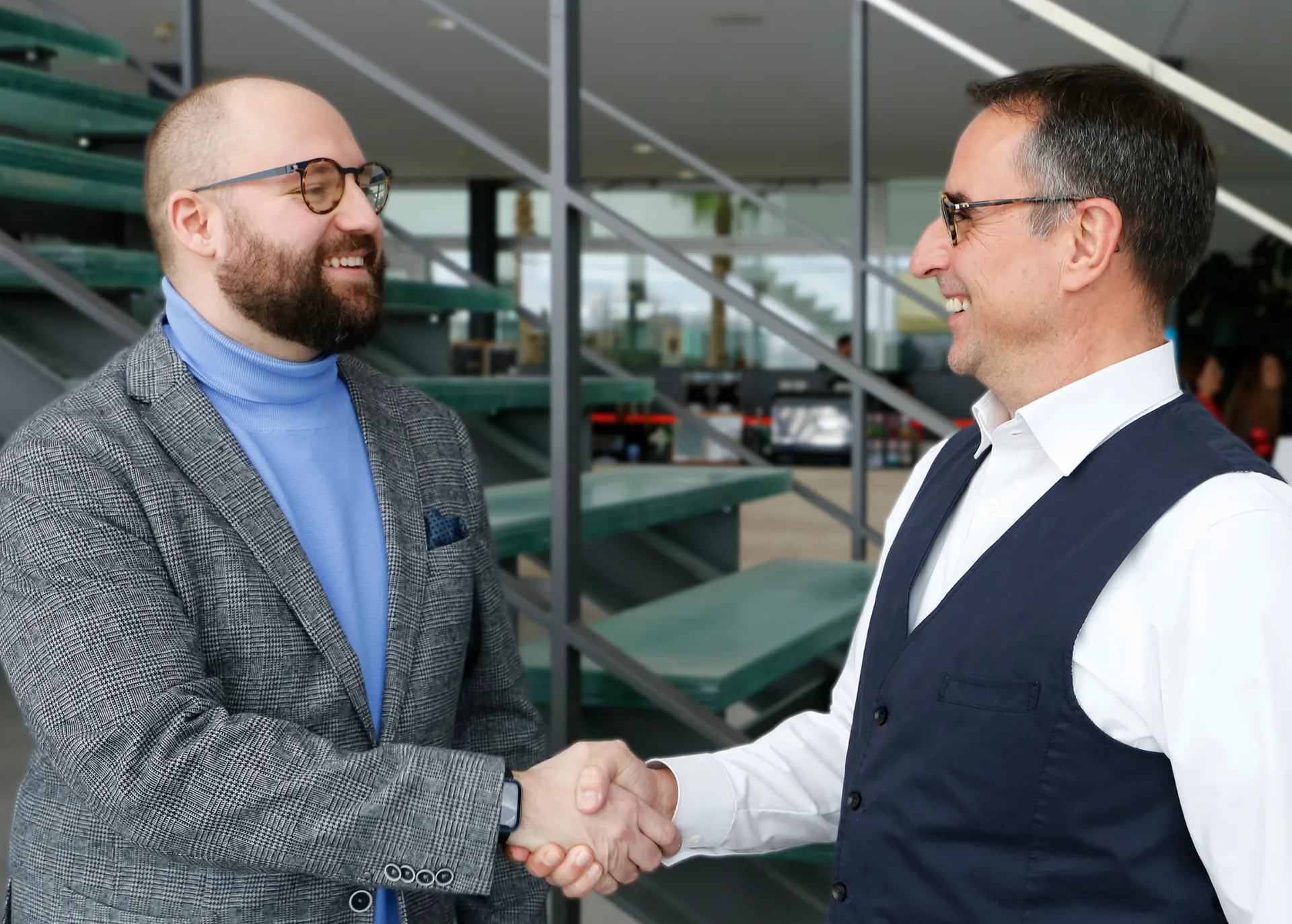 Two men are shaking hands and smiling.