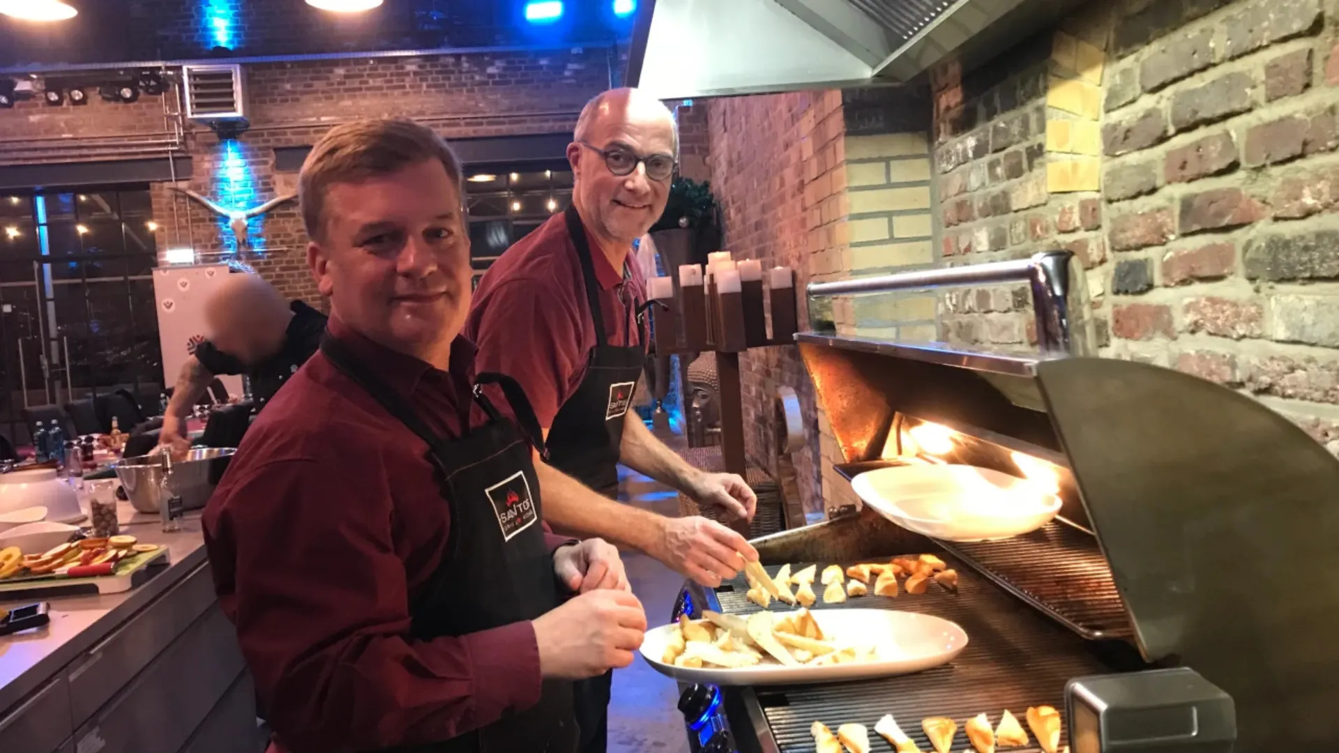 Zwei msg-Kollegen beim gemeinsamen Grillen während des Alumni-Winterevents